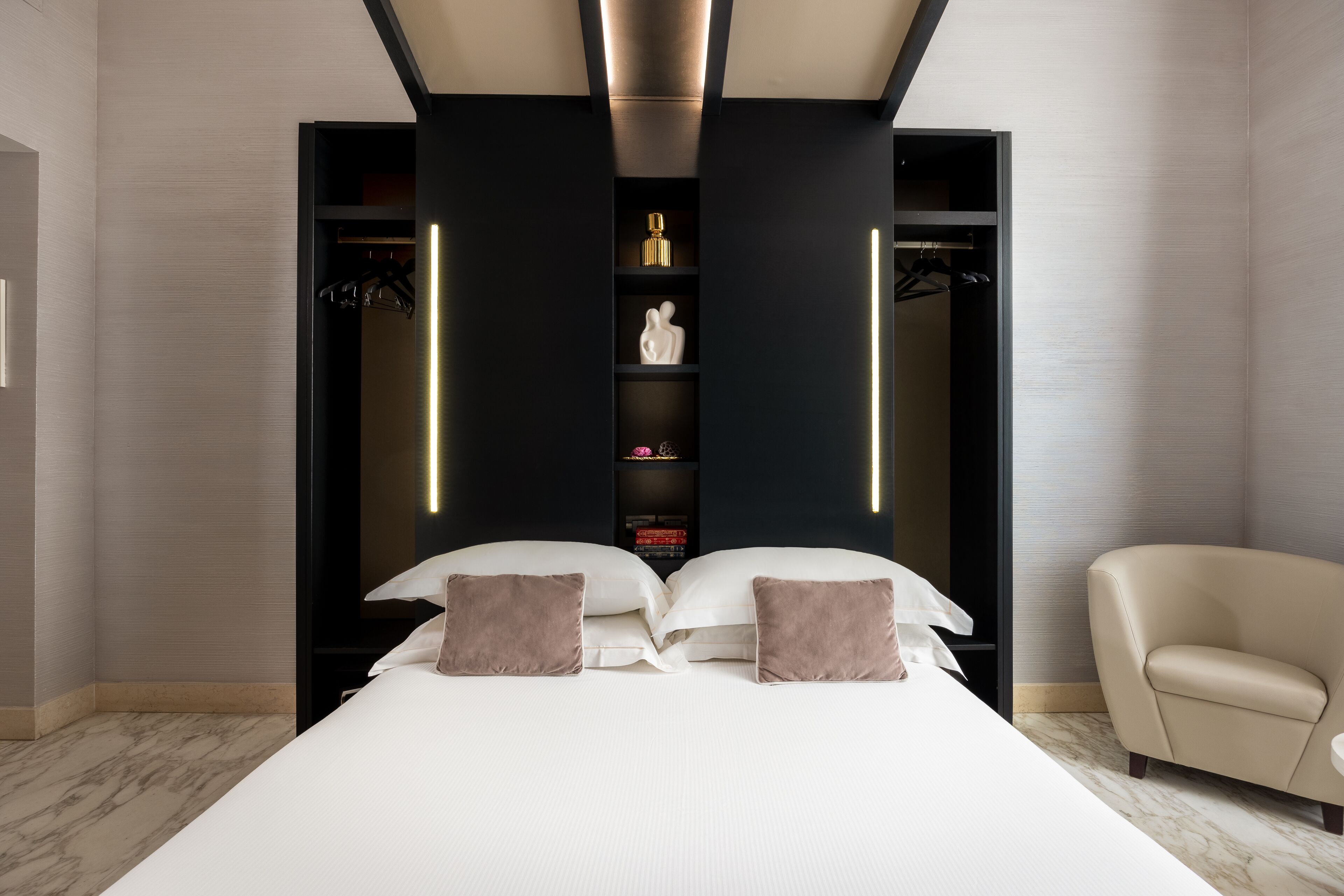 Una camera da letto moderna con un letto grande, un armadio a muro e una zona salotto.