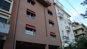 Un edificio a più piani con un tendone rosso su cui è scritto "White Lotus Hotel" al piano terra.