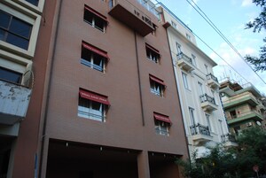A multi-story building with a red awning labeled "White Lotus Hotel" on the ground floor.