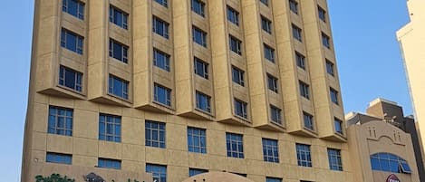 A tall hotel building with multiple floors, a glass entrance, and a sign indicating it is a Best Western Plus property.