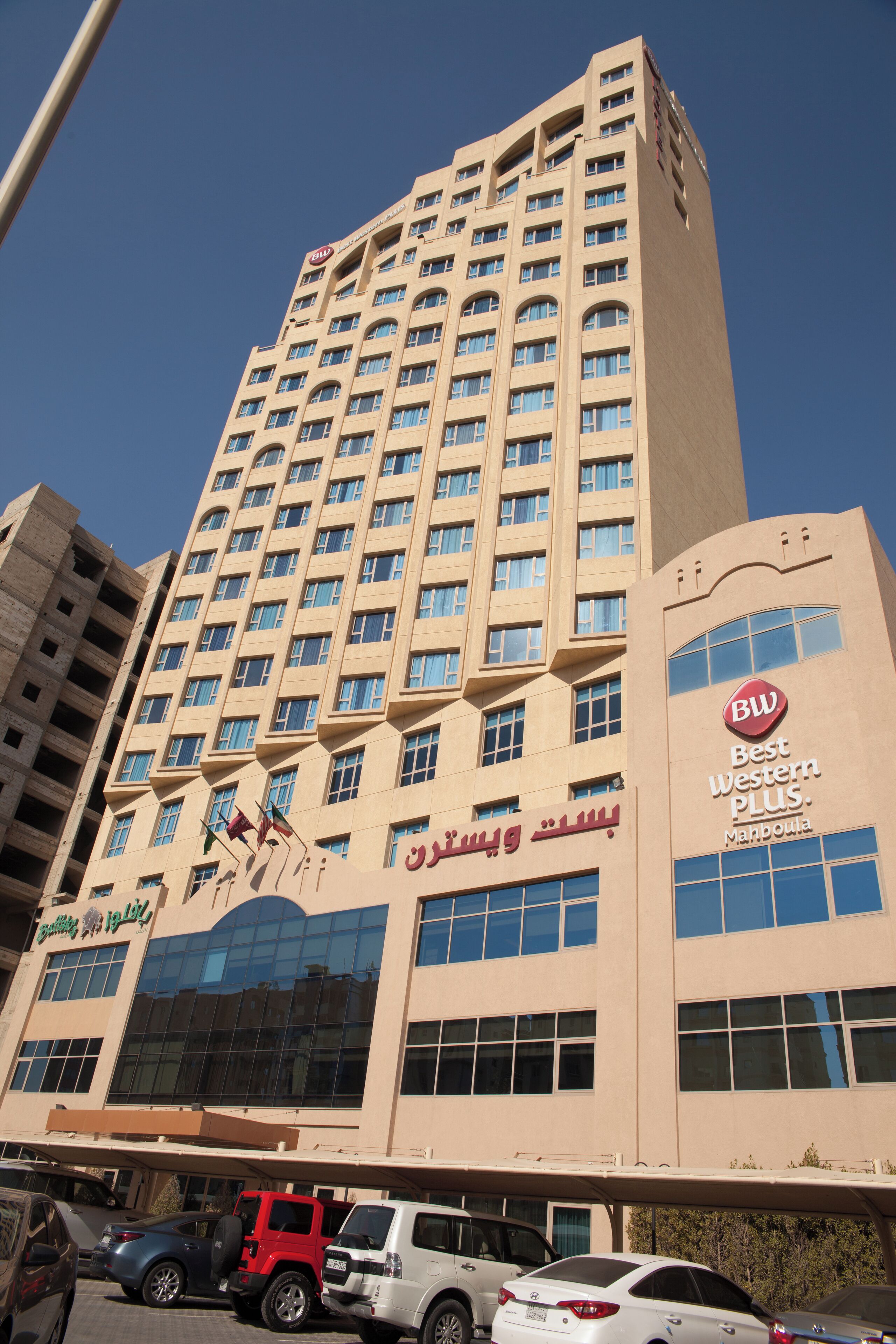 Un hotel alto con varios pisos, grandes ventanales y un letrero llamativo de Best Western Plus.