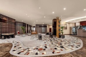 A spacious lobby with a circular patterned floor, seating areas, and a reception desk. - Intercity Hotel (Baoji)