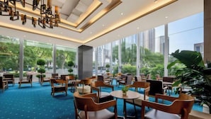 A spacious indoor area with multiple seating arrangements, large windows, and a view of greenery outside. - Intercity Hotel (Baoji)