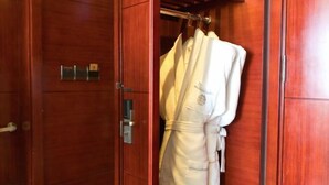 A wooden wardrobe with a robe hanging on a rod. - Intercity Hotel (Baoji)