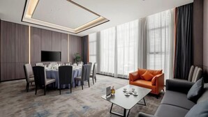 A modern hotel room with a dining area, a sofa, and a flat-screen TV. - Intercity Hotel (Baoji)