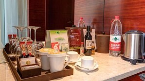 A hotel room's breakfast setup with a coffee machine, tea kettle, and various food items. - Intercity Hotel (Baoji)