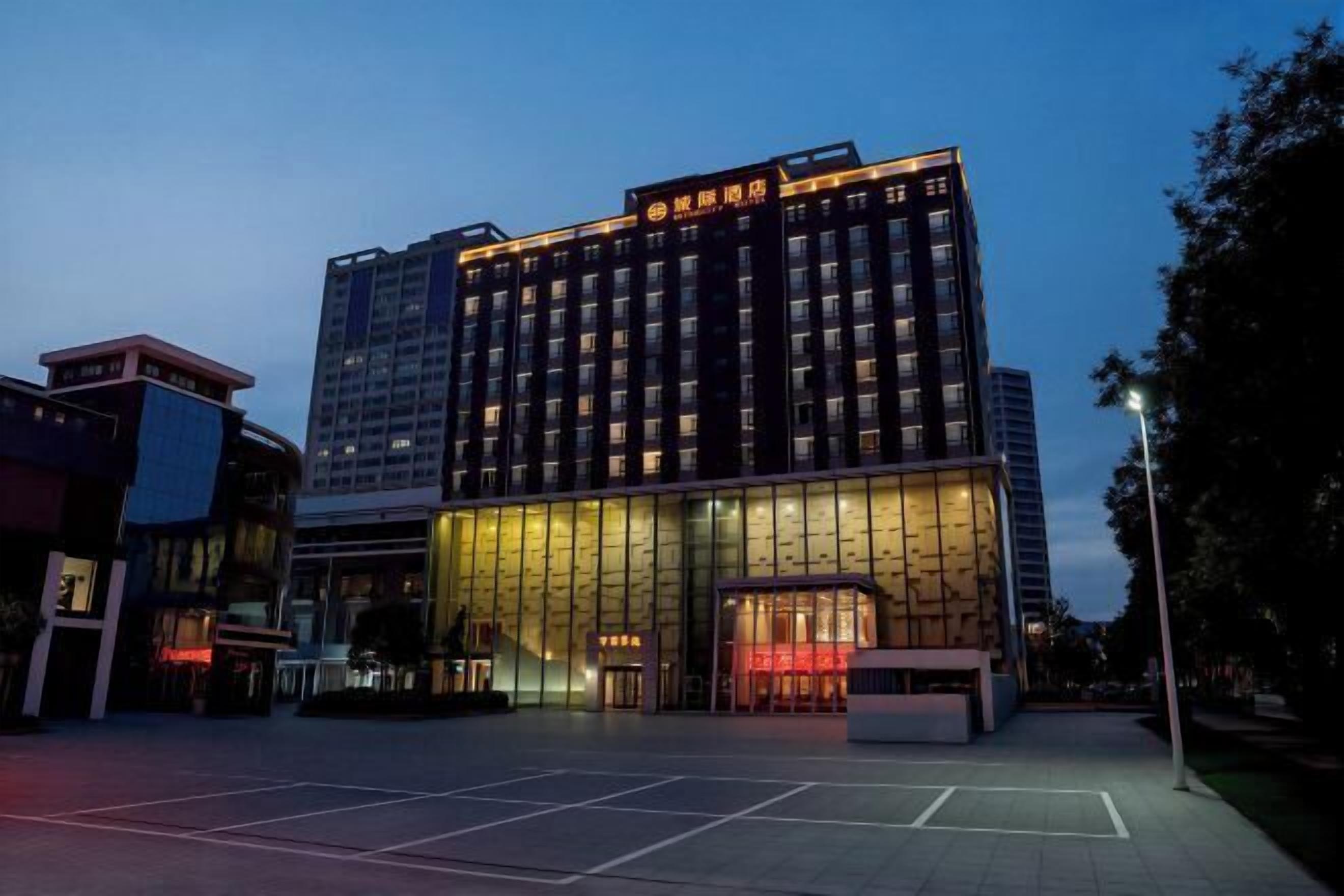 A multi-story hotel with a modern facade, large glass windows, and a prominent entrance.