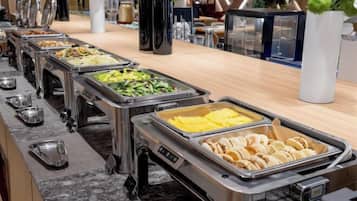 A buffet with multiple food stations, including a variety of dishes and a coffee station.