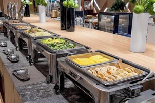Un bufé con varias estaciones de comida, que incluye una variedad de platos y una estación de café.