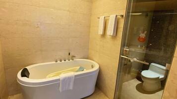 Une salle de bain avec une baignoire, des toilettes et une douche à parois de verre.