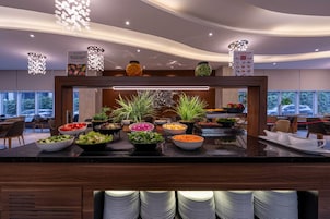 Un'area buffet con diverse opzioni gastronomiche e una scelta di ciotole e piatti.