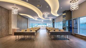 A modern conference room with curved ceiling lights, wooden floors, and large windows.