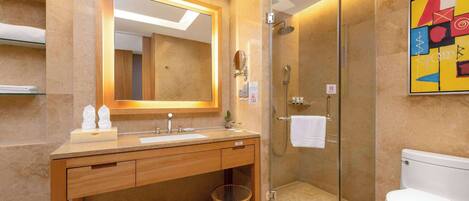 A modern bathroom with a glass-enclosed shower, a wooden vanity with a mirror, and a white toilet.
