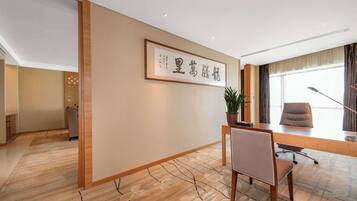 A modern office with a wooden desk, a chair, and a framed sign on the wall.