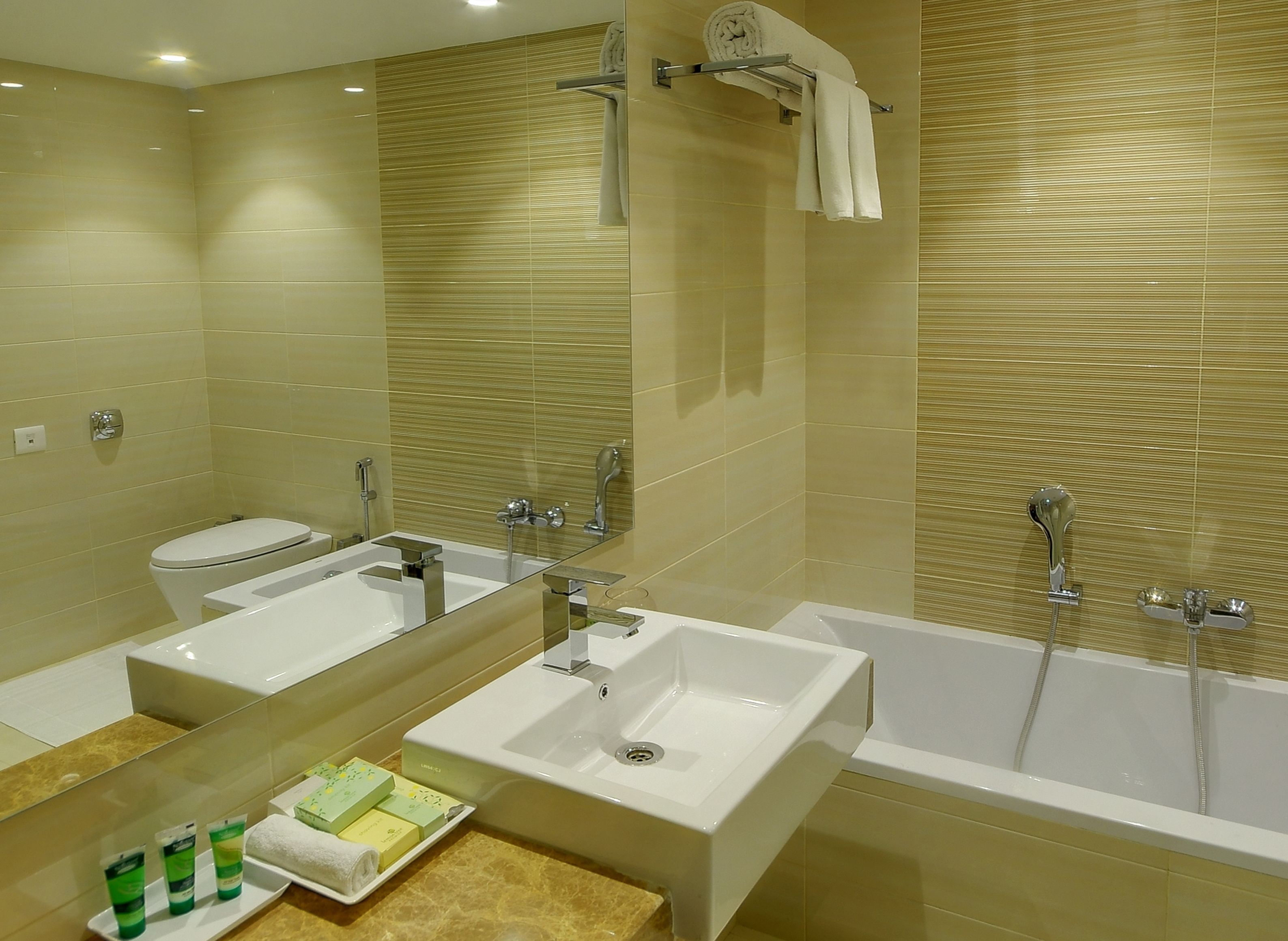 Un baño moderno con dos lavamanos, un inodoro y una bañera.