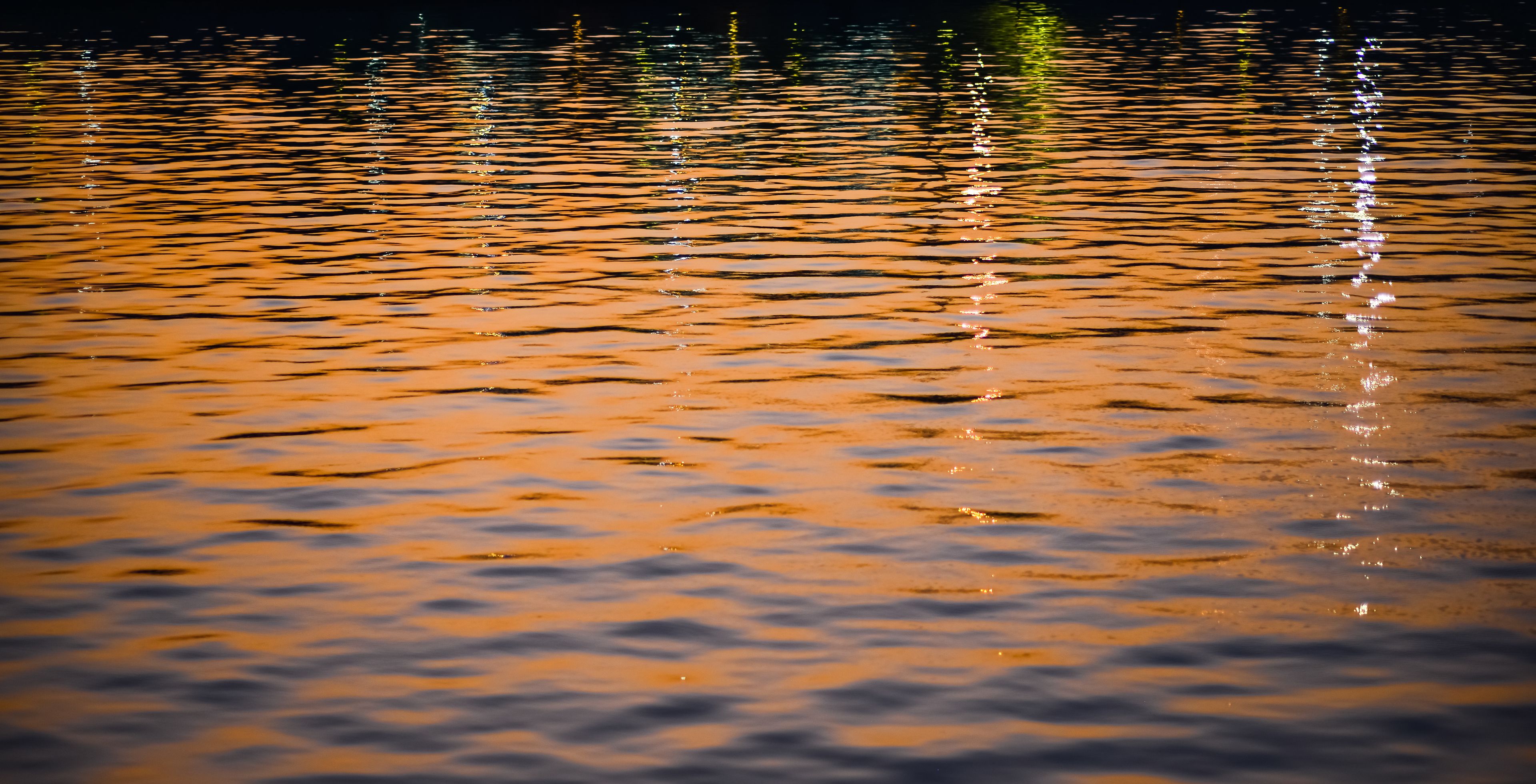 Rustig wateroppervlak dat licht weerkaatst.