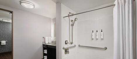 Un bany modern amb banyera, dutxa i un lavabo amb mirall.