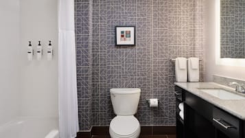 Un baño moderno con inodoro, ducha y lavamanos.