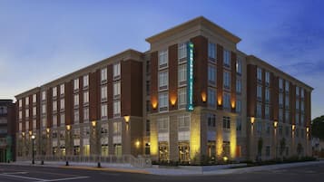 A multi-story hotel with a brick facade, large windows, and a prominent sign indicating it is a Homewood Suites.