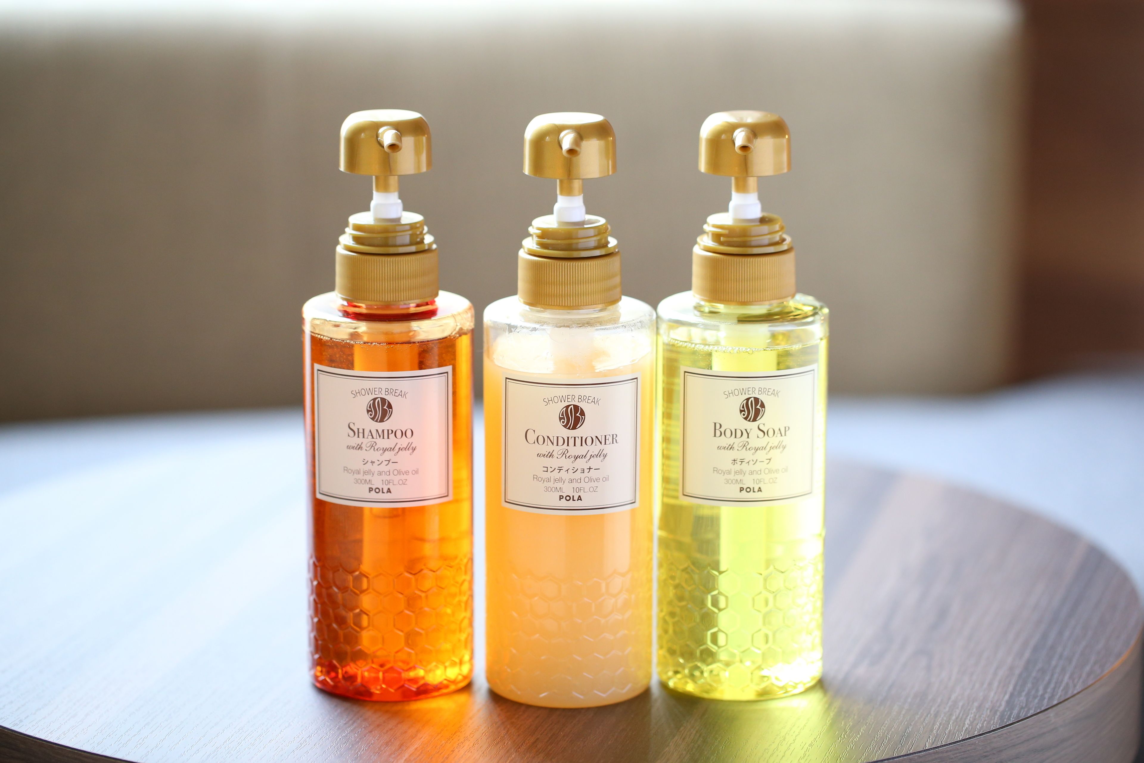Three bottles of shower products on a wooden surface.