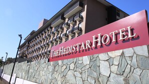 Un letrero de hotel con el nombre "The Hedistar Hotel" sobre una pared de piedra.
