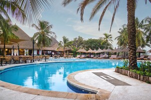 Una piscina al aire libre, sillones reclinables de piscina