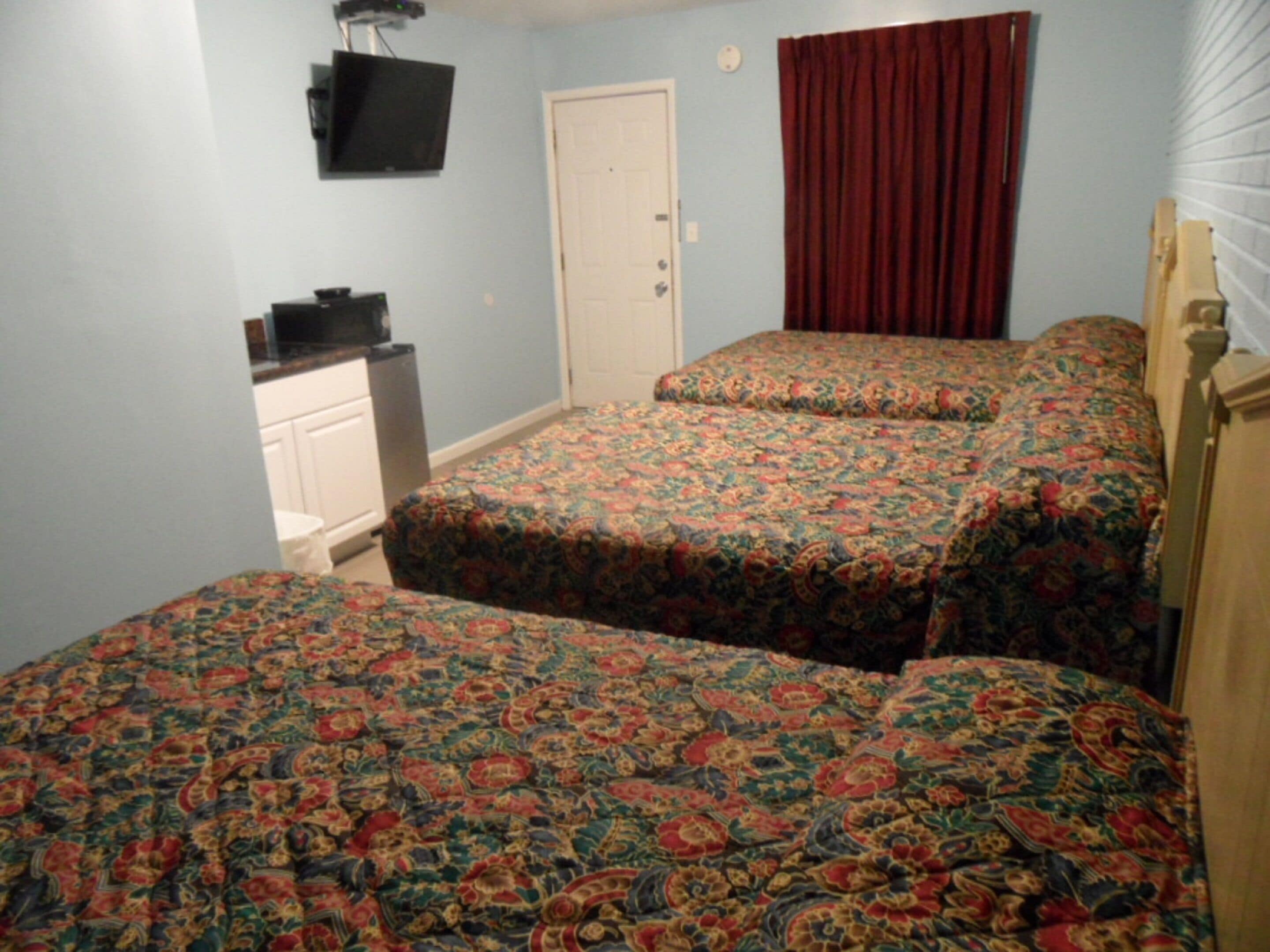 Un dormitorio con dos camas, un televisor y un aparador.