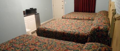 Un dormitorio con dos camas, un televisor y un aparador.