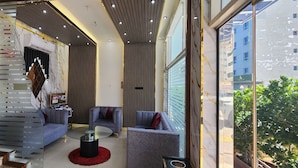 A modern living room with a glass coffee table, two sofas, and a red rug. - Al Smou Hotel Apartments (Ajman)