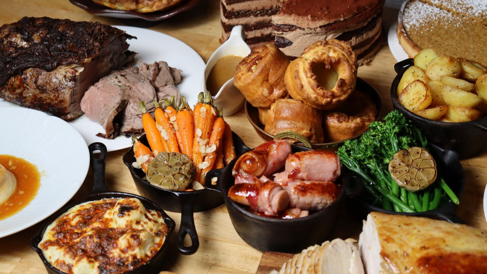 A variety of dishes including roasted meat, vegetables, and bread.