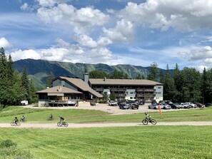 A lodge with a large parking area and mountain views.