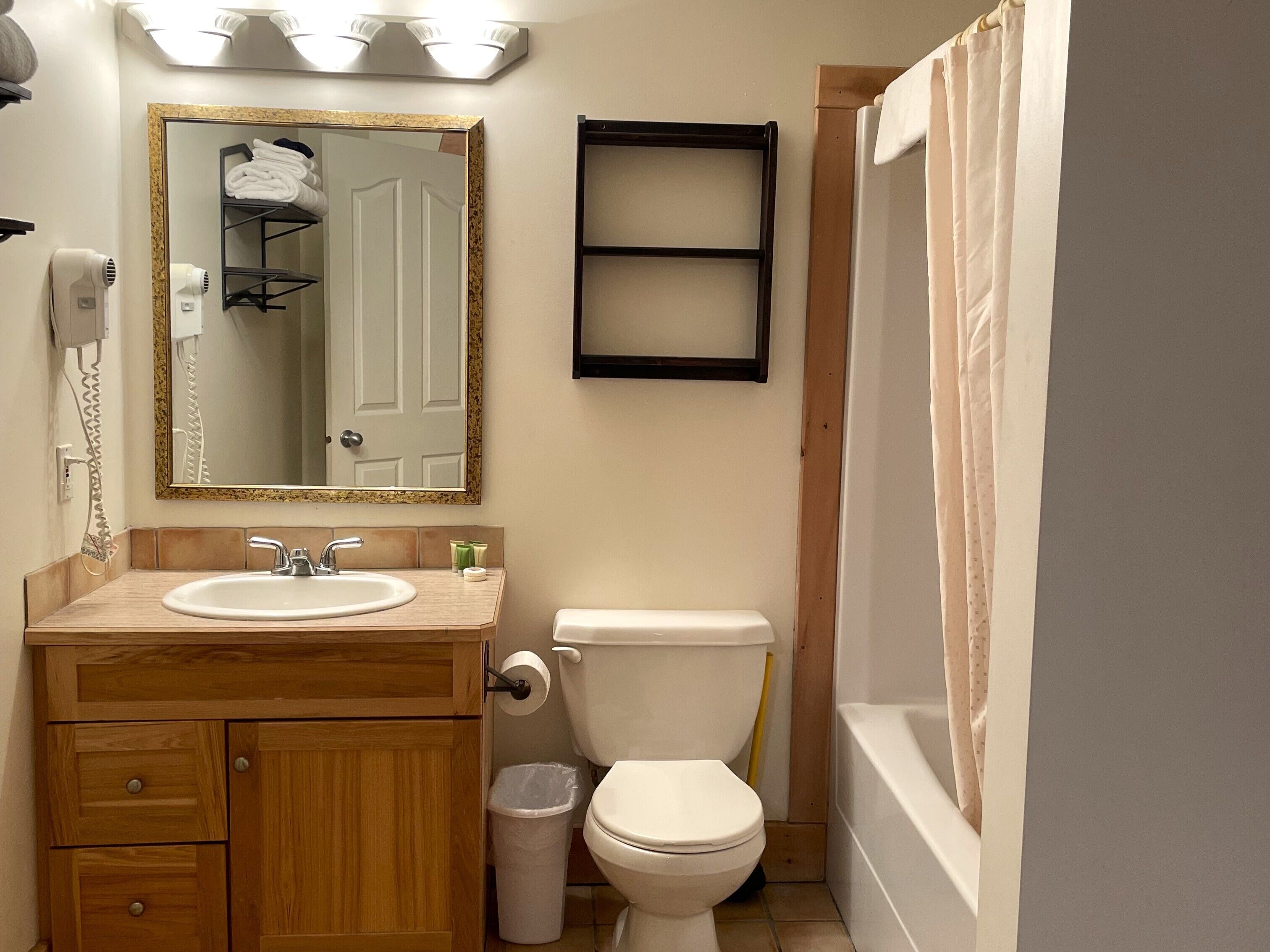 A bathroom with a sink, toilet, and shower curtain.