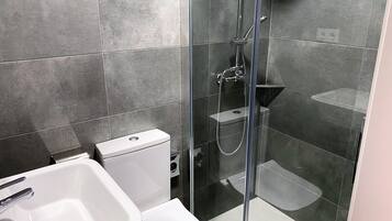 Twin kamer | Badkamer | Een douche, een haardroger, handdoeken, zeep
