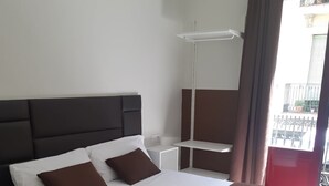 Een hotelkamer met een groot bed, een nachtkastje en een raam met uitzicht.