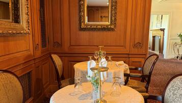 A dining room with a round table, chairs, and a mirror on the wall.