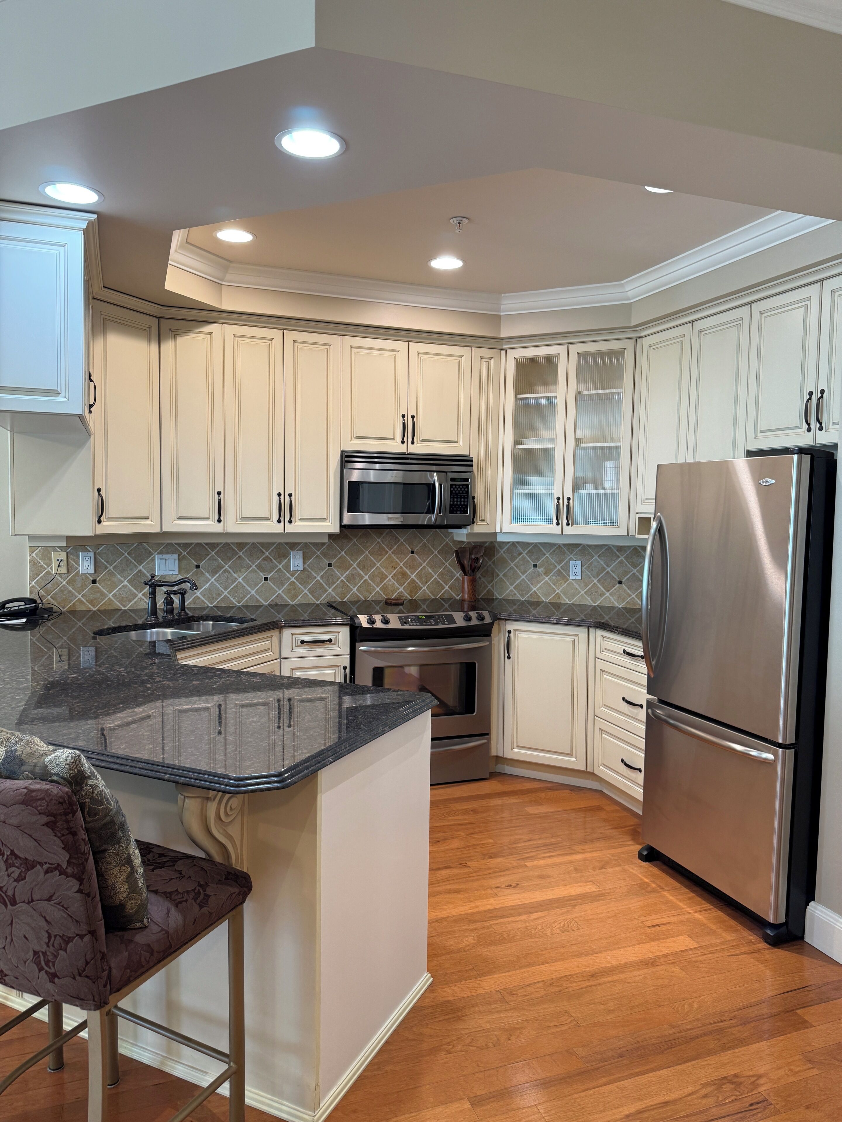 A modern kitchen with built-in appliances, a central island, and a curved cabinetry design.