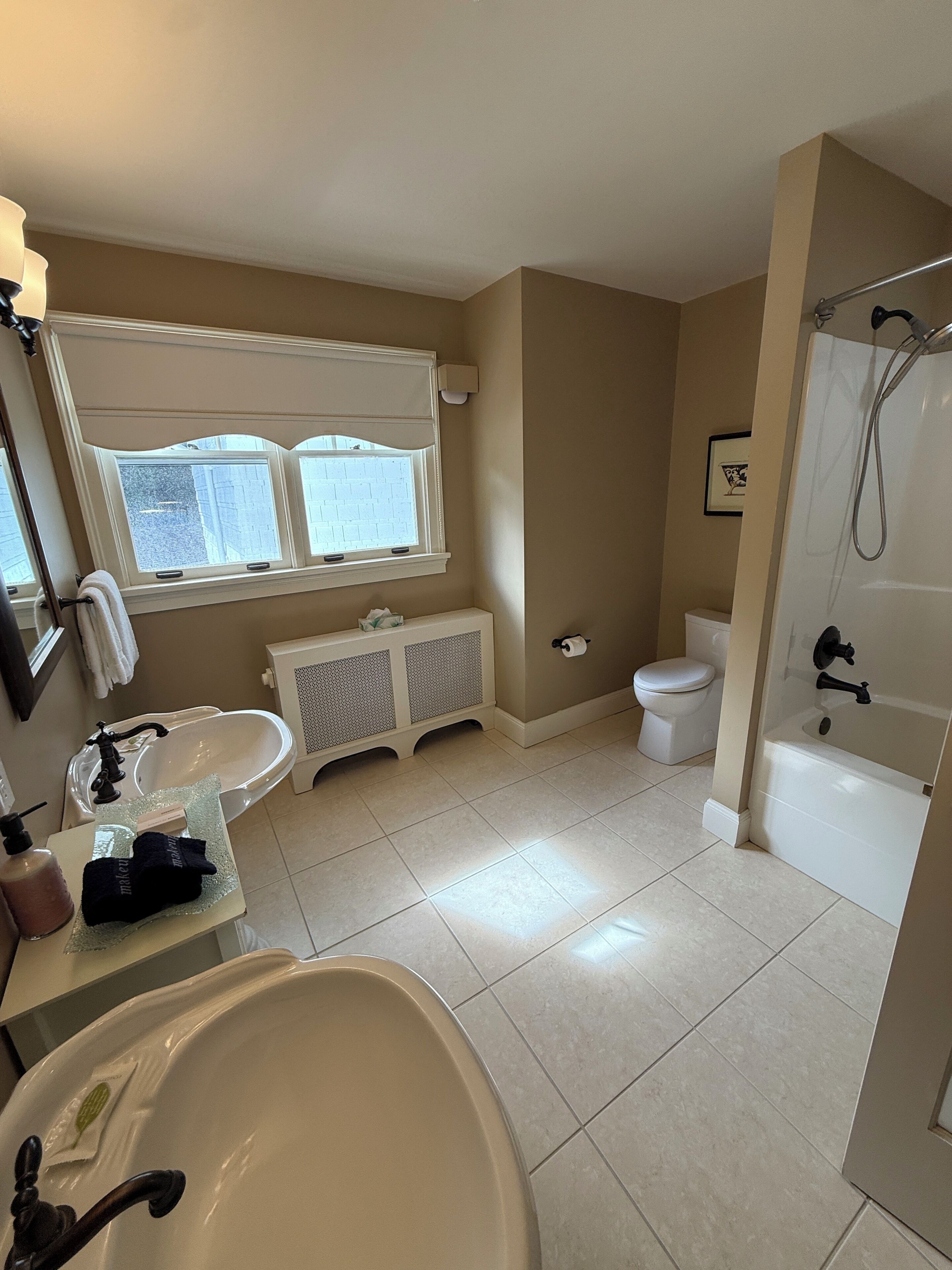 Een badkamer met een wastafel, toilet en bad.