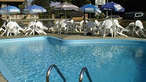 Une piscine avec des chaises longues et des parasols.
