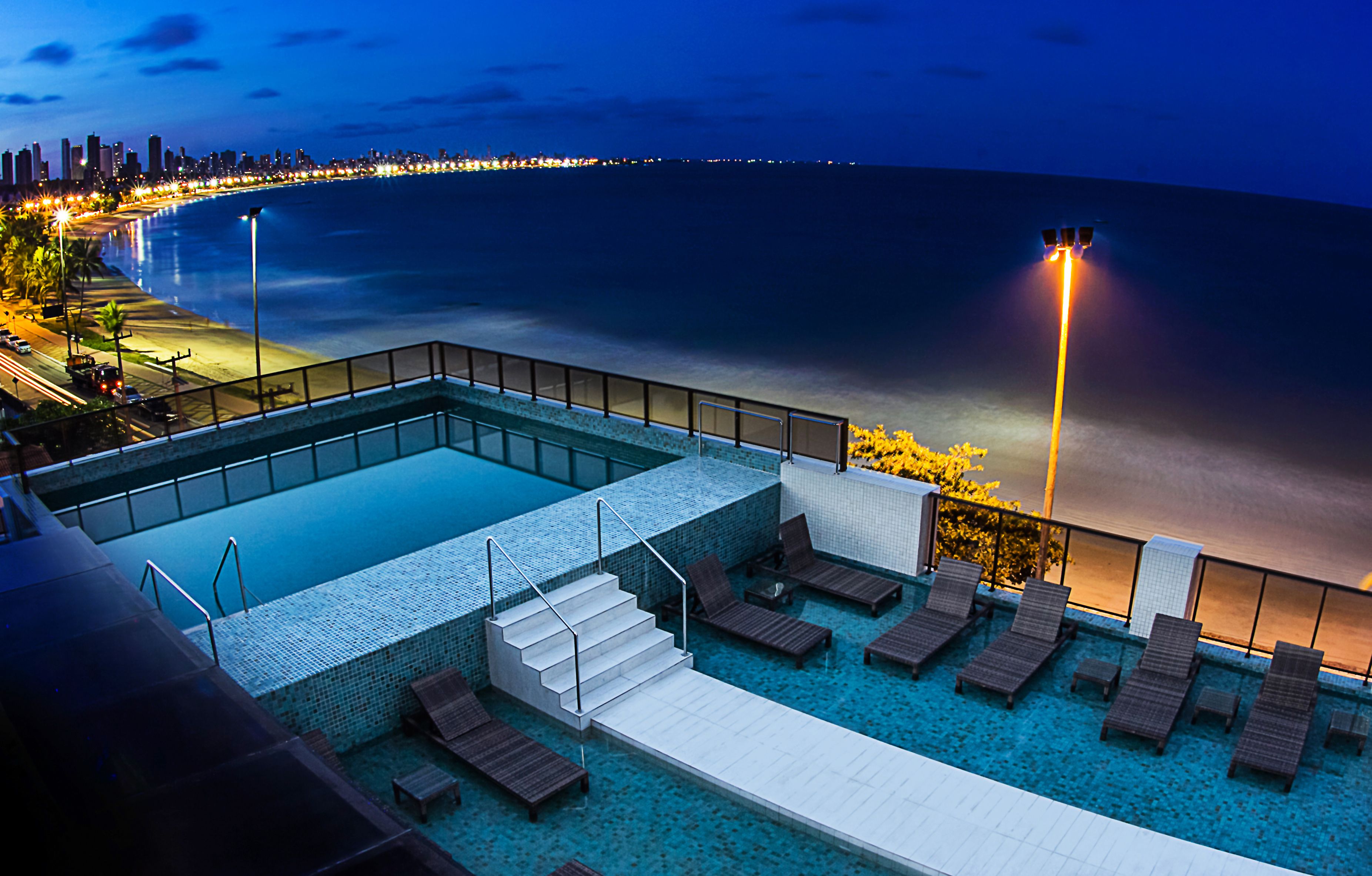 Una piscina al aire libre, sombrillas, tumbonas