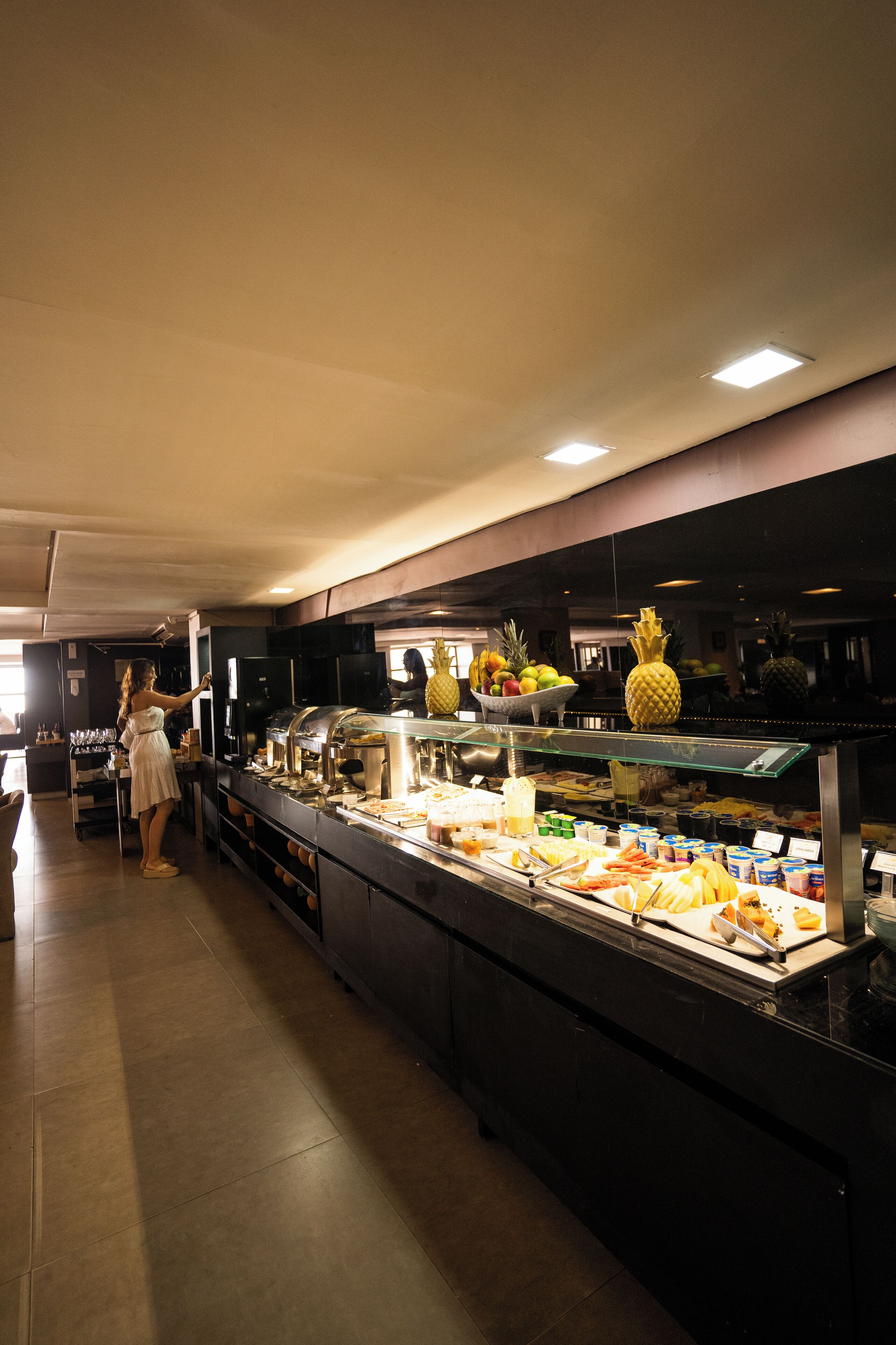 Zona de buffet con diversos alimentos y una persona atendiendo.