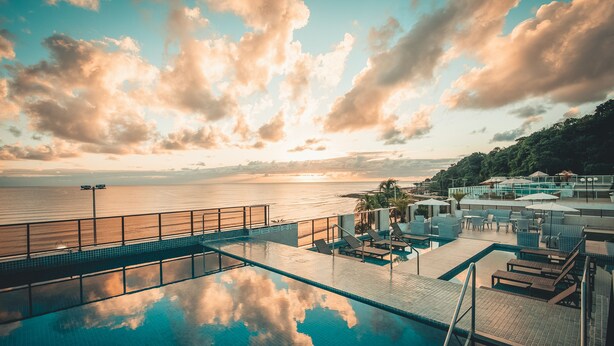 A rooftop infinity pool with a view of the sea and a sunset. - Hotel Cabo Branco Atlântico (João Pessoa)