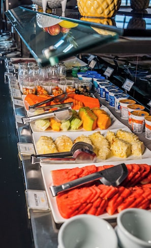 Ein Buffet mit verschiedenen Speisen, darunter Obst, Gemüse und Milchprodukte.