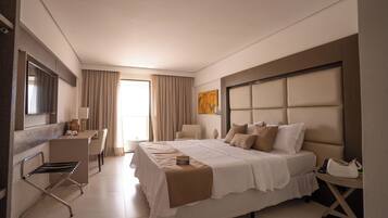A hotel room with a bed, a desk, a chair, and a TV.