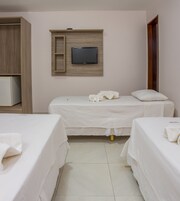 Camera d'albergo con due letti, una televisione a parete e un armadio.