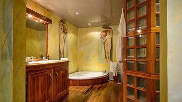 Un baño con tocador de madera, una bañera y un armario de vidrio.
