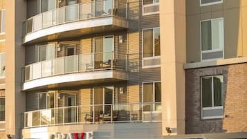 A multi-story hotel with a modern design, featuring balconies and large windows.