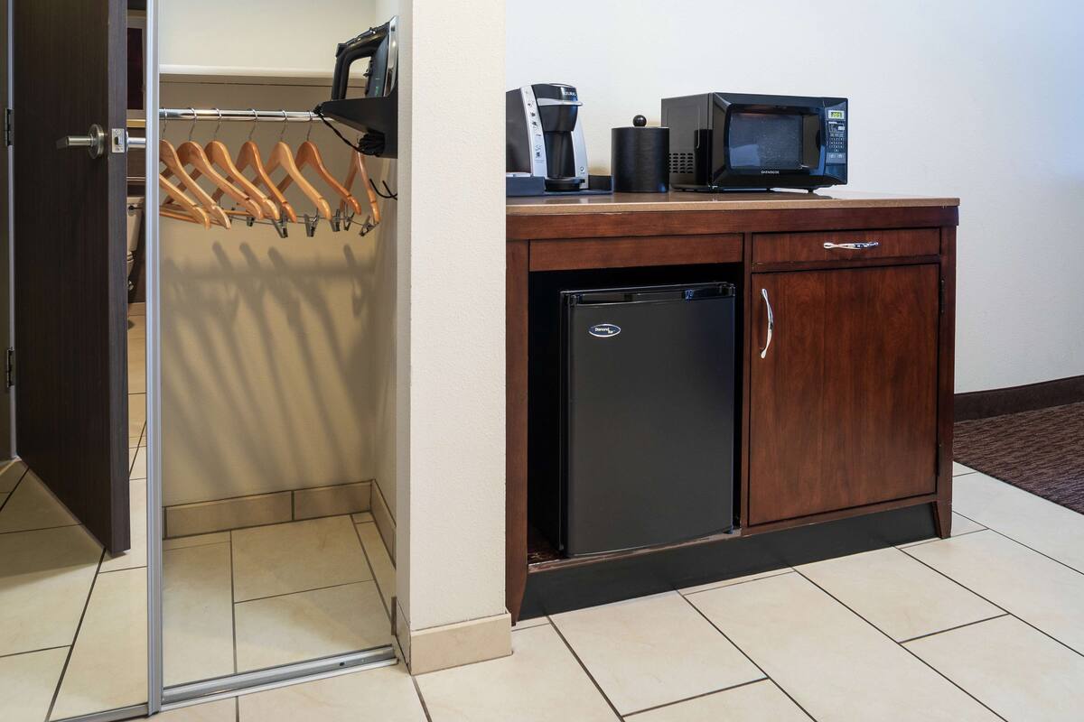 Une petite cuisine équipée d’un réfrigérateur, d’un four à micro-ondes et d’une machine à café.