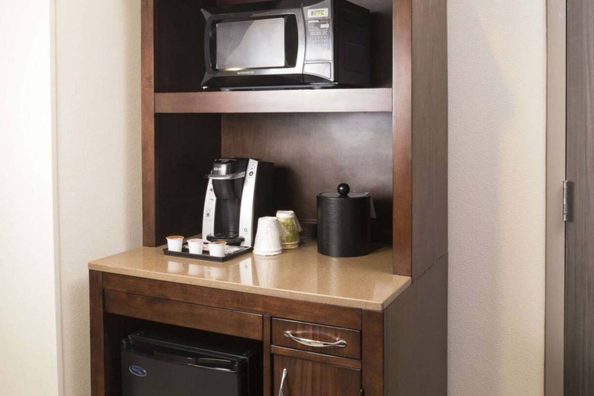 Une petite cuisine équipée d’un four à micro-ondes, d’une machine à café et d’un réfrigérateur.