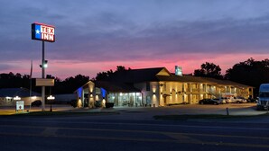 A Tex Inn motel with a large sign, a truck parking area, and a building with multiple rooms. - Motel 6 New Boston, TX (New Boston)