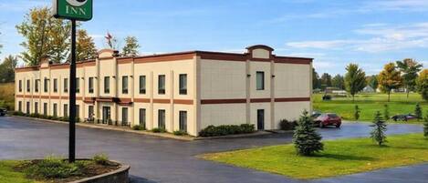 A Pleasant Inn building with a flat roof, multiple windows, and a parking lot.